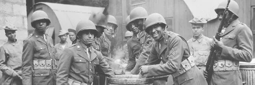 Black 美国 soldiers draw rations at the camp cook house at their station in Northern Ireland during World War Two