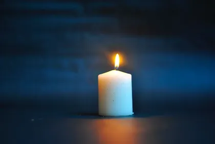 在深蓝色的背景下，点燃的白色蜡烛