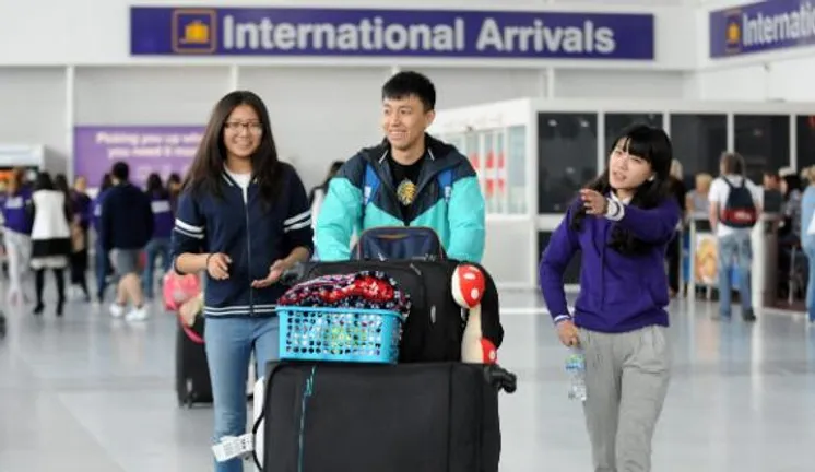 3 international students walking through the airport