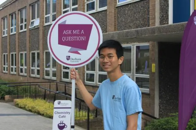 Student ambassador holding an ask me sign during an open day