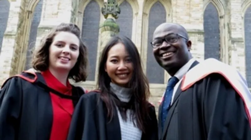 Three graduates standing outside the Cathedral