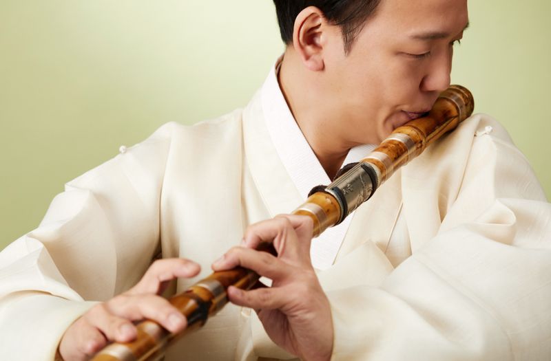 一个男人吹着韩国的竹笛