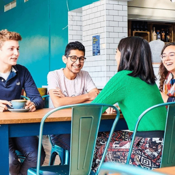 四个学生围坐在一张咖啡桌旁