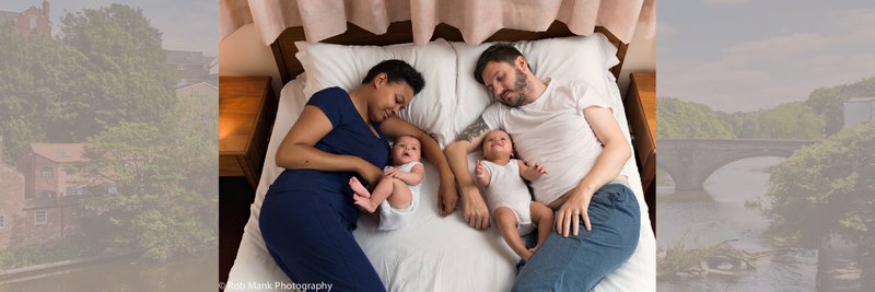 父母躺在婴儿旁边，床上垫着买足球app - 365下载-apple app store衬垫