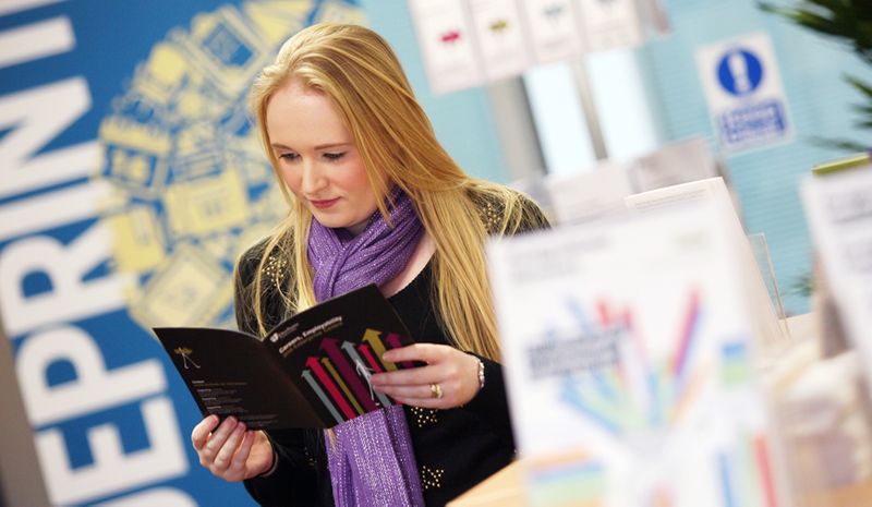A student browsing various brochures and pamphlets in the Careers and Enterprise Centre
