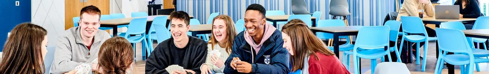 A mixed group of students chatting in a college bar