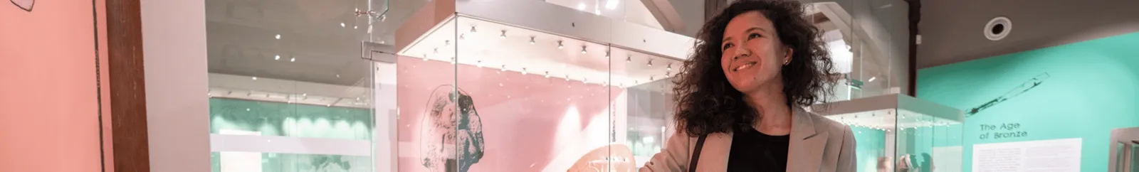 A woman examining an exhibit in the Museum of Archaeology