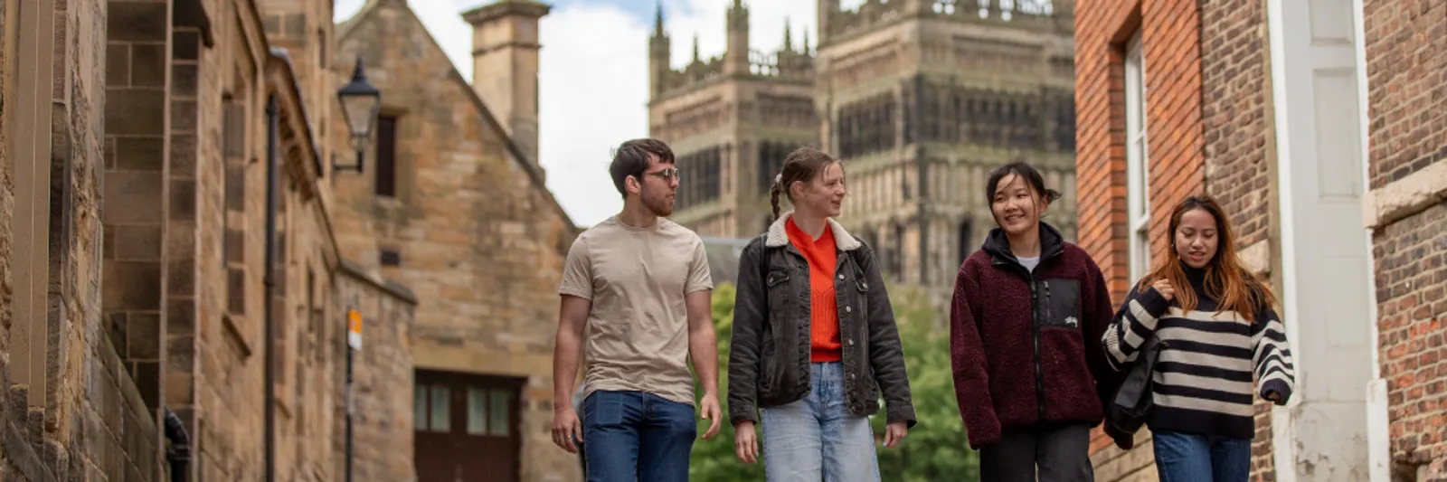 Four students walking down The Bailey, away from the Cathedral