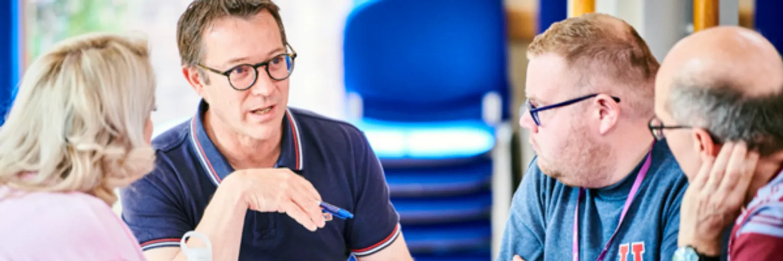 A group of people, in discussion, sitting around a table at a conference