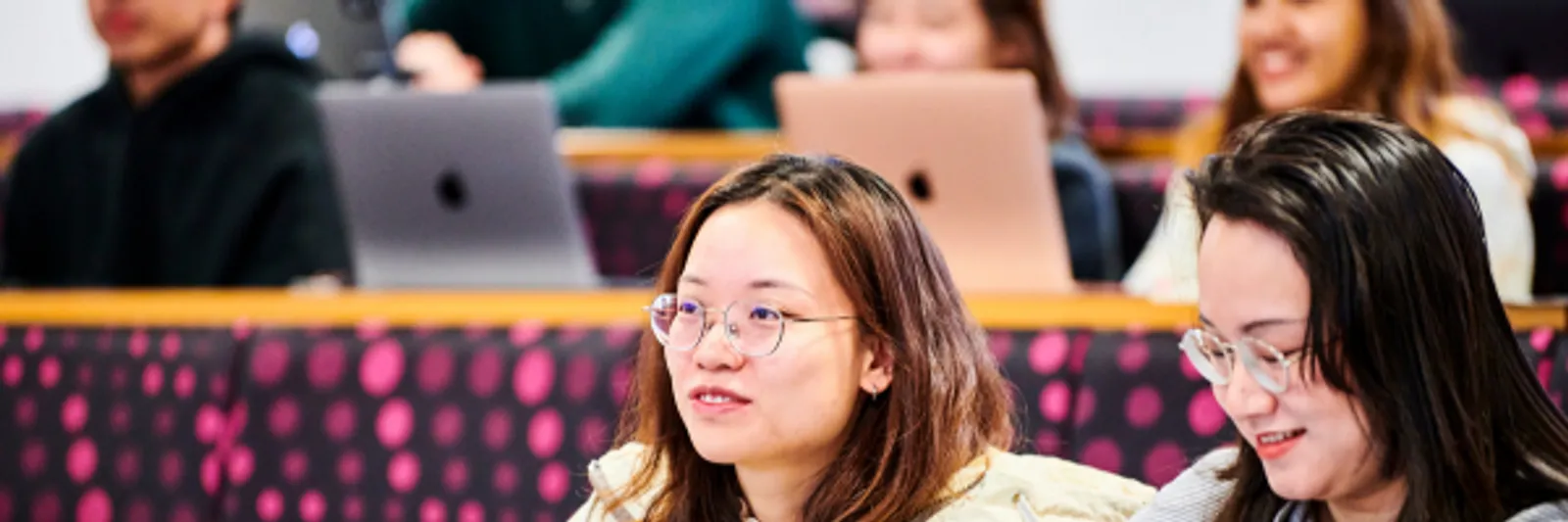 Law students sit in a lecture theatre - they are serious and concentrating