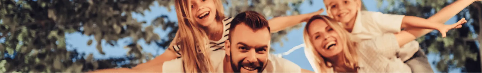 A family piggy backing children with arms spread wide