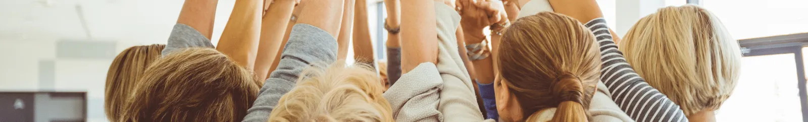 A group of women with their hands held together in the air