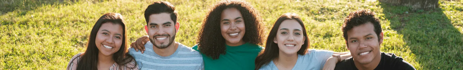 A group of friends sat on a rug in the park