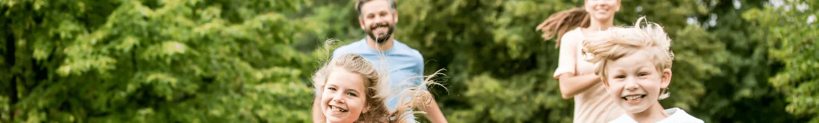 A family running in the park with their dog