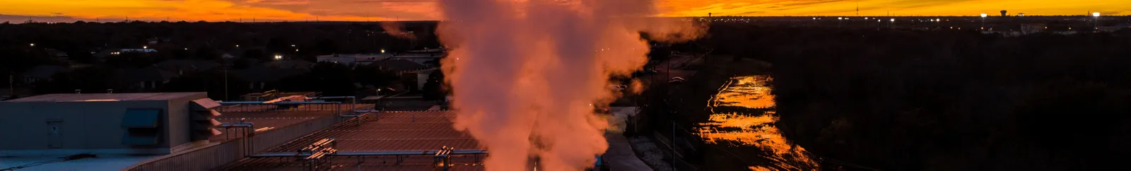 Smoke and air pollution at sunset over buildings