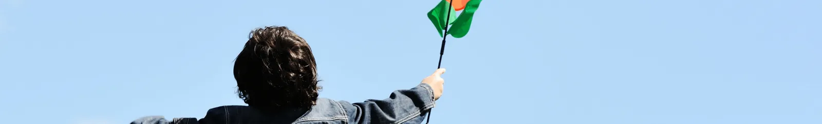 A child from behind holding a colourful object