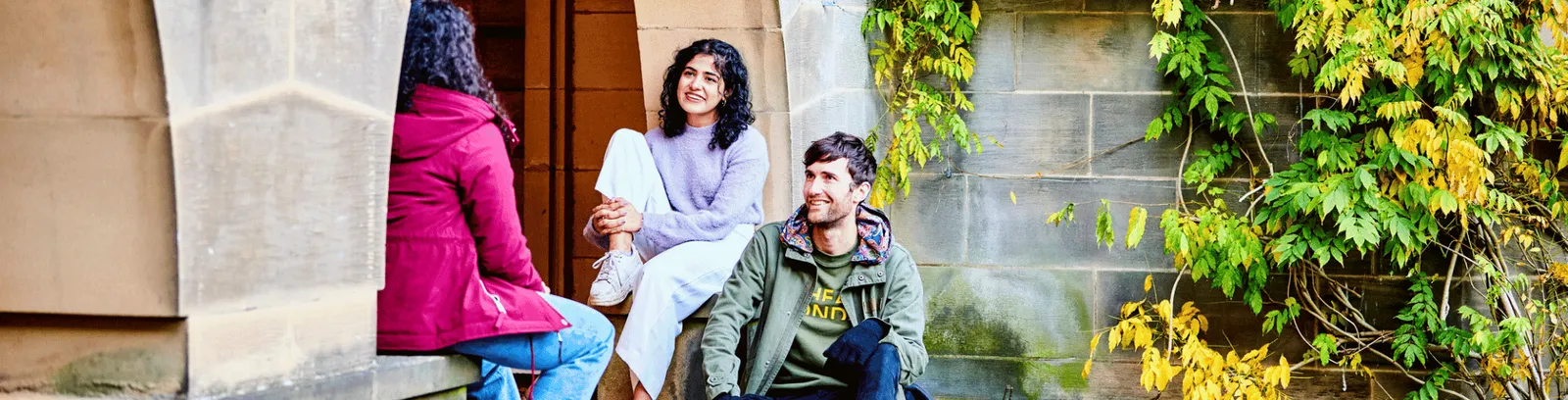 Three students sat on the steps of St Marys College