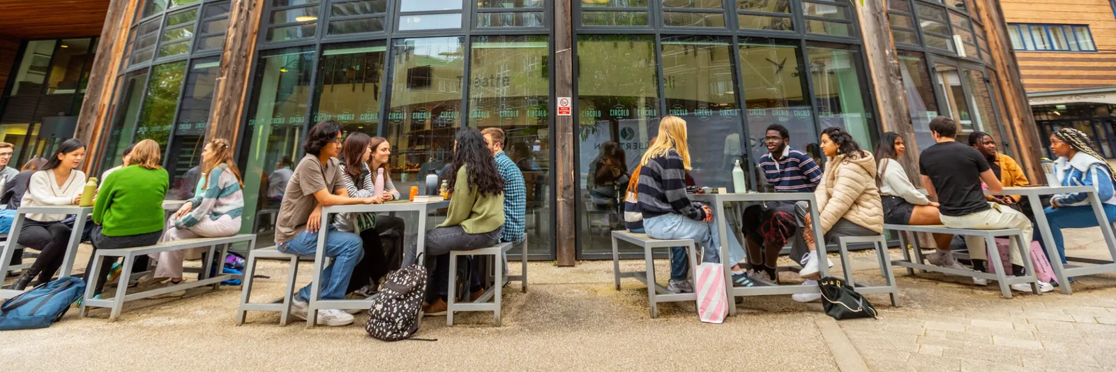 Students sat at tables outside on campus