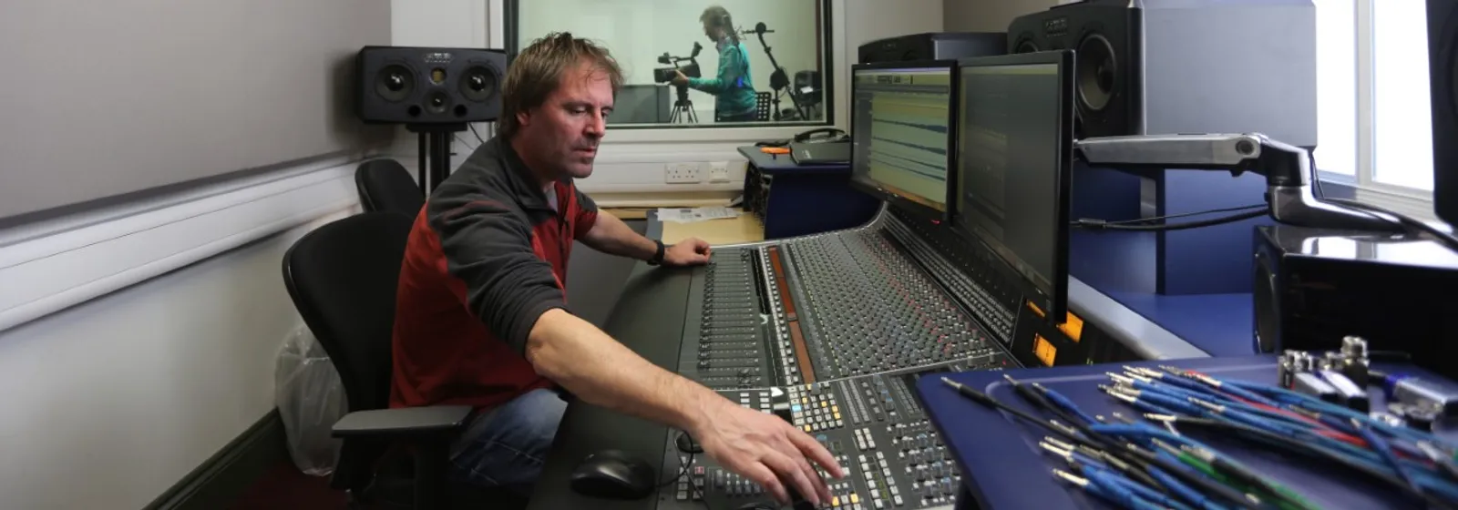 Technicians in a music booth adjusting the equipment