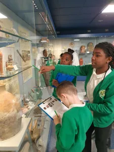 School children exploring in a museum and pointing at the exhibitions