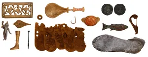 A coloured photograph of a number of objects found by divers in Piercebridge. Objects in the photograph include a spoon, scale armour, rings, coins, a fish hook, brooches and even the sole from a shoe.