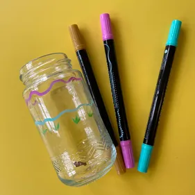 Materials for a glass decorating workshop: pens and glass jar