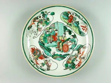 Chinese plate decorated with green, blue and orange designs.