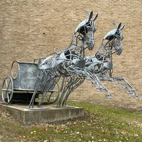 Life size metal sculpture of two horses pulling a chariot