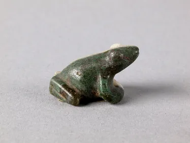 Small statue of a dark green frog with black speckles