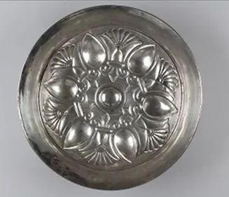 Silver disc embossed with a floral pattern starting from the centre.