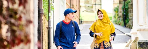 Two students talk as they walk down the cobbled street of Bow Lane, Durham