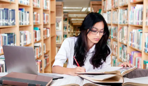 A female student doing assignments in a library