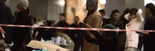 A group of women standing around with bags on the floor.