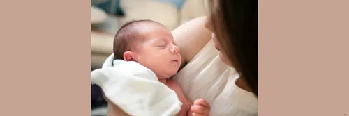 A mum holding a newborn baby in her arms.