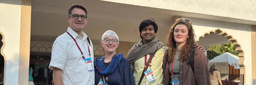 Four people standing smiling at the camera