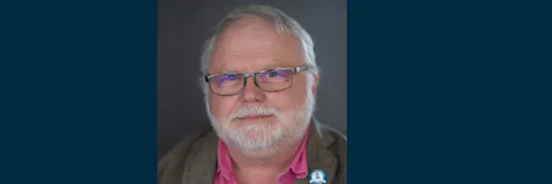 Professor Jon Gluyas looking straight to camera in front of a dark background