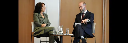 Man and woman sitting at table, man talking