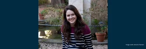 Dr Katherine McDonald smiling and facing the camera whilst sat in an outdoor setting