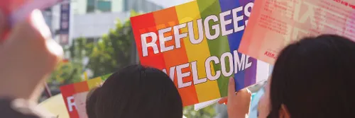 A banner saying refugees welcome at a protest march