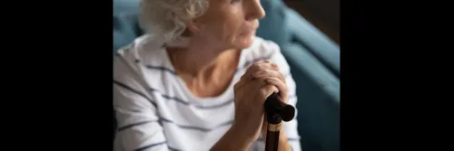 An older woman holding a stick