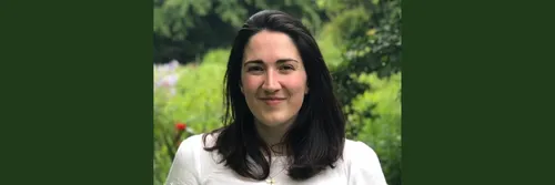 Woman facing camera, smiling. Head and shoulders visible