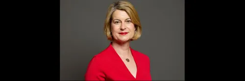 A woman, visible from shoulders upwards, looking directly at camera