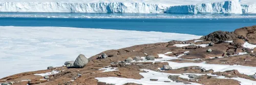 Rock and ice in the foreground with sea and ice in the background.