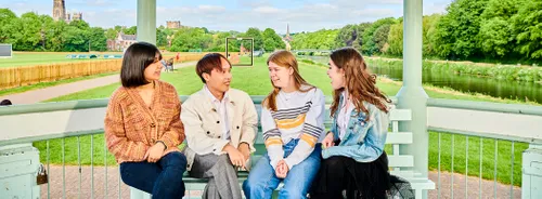 A group of students chatting on a bench