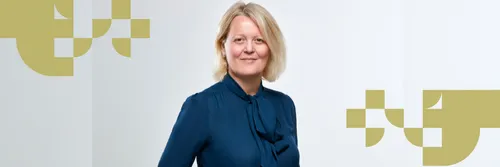 Alison Rose with blonde hair wearing a dark blue blouse and smiling.