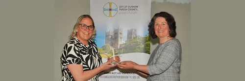 Andrea with blonde hair and glasses is smiling as she receives her award from Councillor Susan Walker, Chair of City Durham Council
