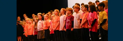 School chlidren singing on a theatre stage