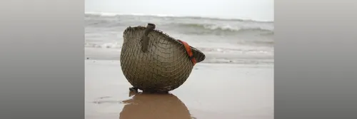 A soldier's helmet upturned on a sandy beach