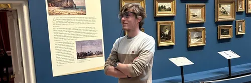 A ֱ male student demonstrates wearing a pair of eye tracking technology glasses at The Bowes Museum