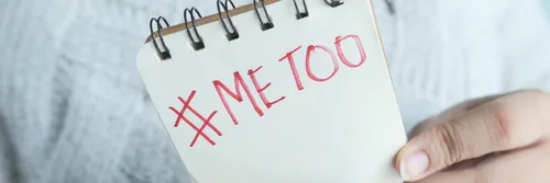 A hand holding a notepad that says #metoo